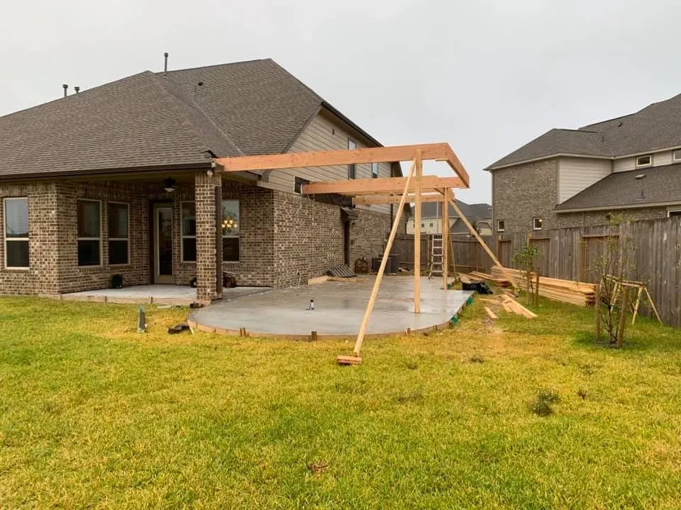 Backyard playset and patio area behind a custom home