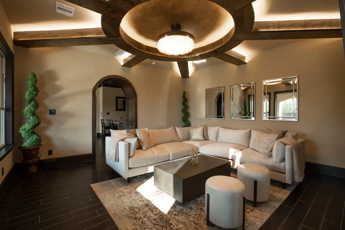 Luxury living room with tray ceiling, chandelier, and neutral sectional