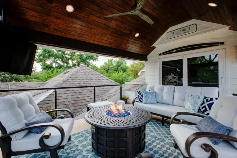 Covered patio seating area with wood ceiling and outdoor fire table