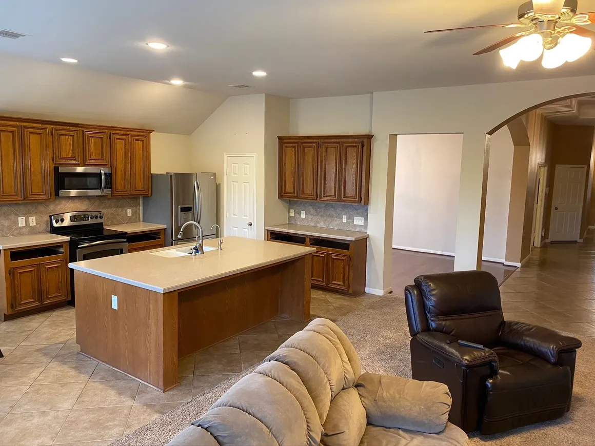 Open kitchen and living area with large island and leather recliner