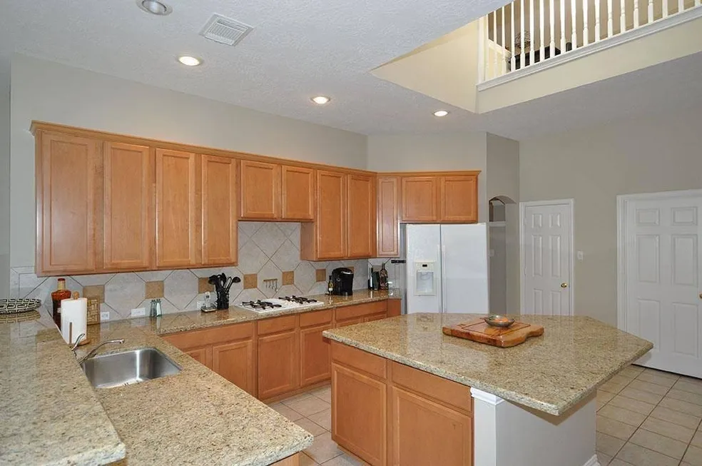 Bright kitchen with light wood cabinetry and white countertops