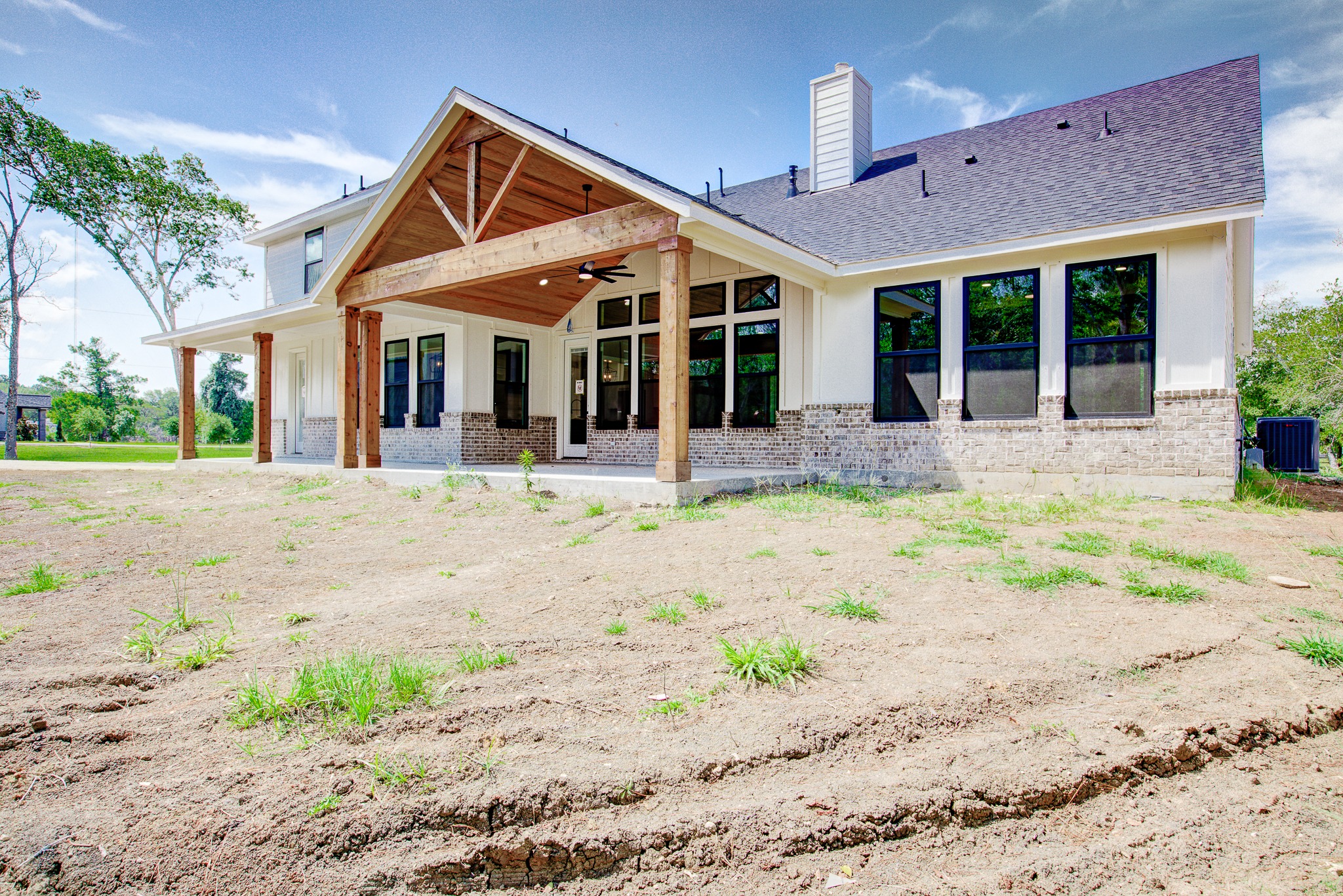 New custom home exterior with timber entry beams and covered porch