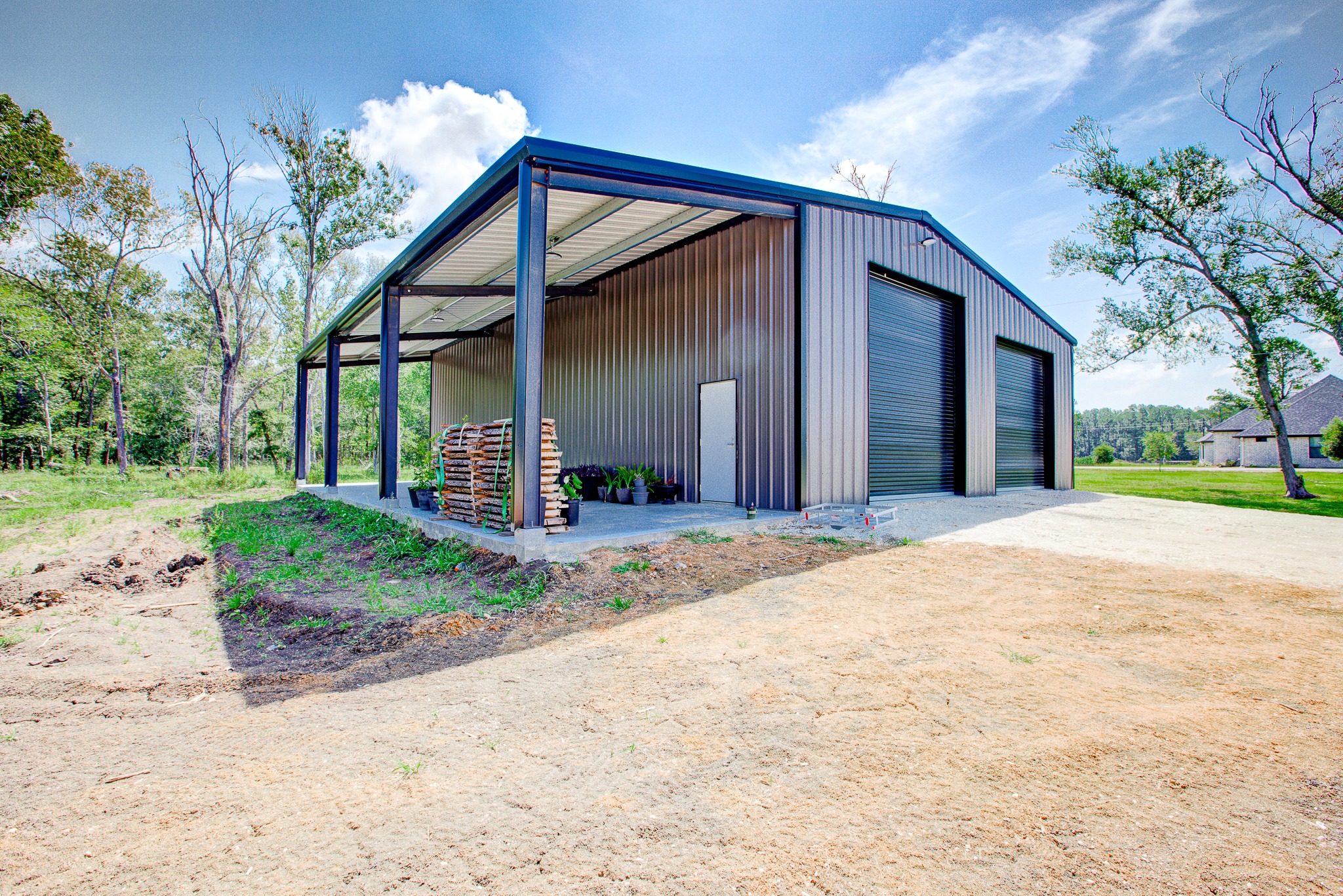 Blue metal workshop building with gravel driveway