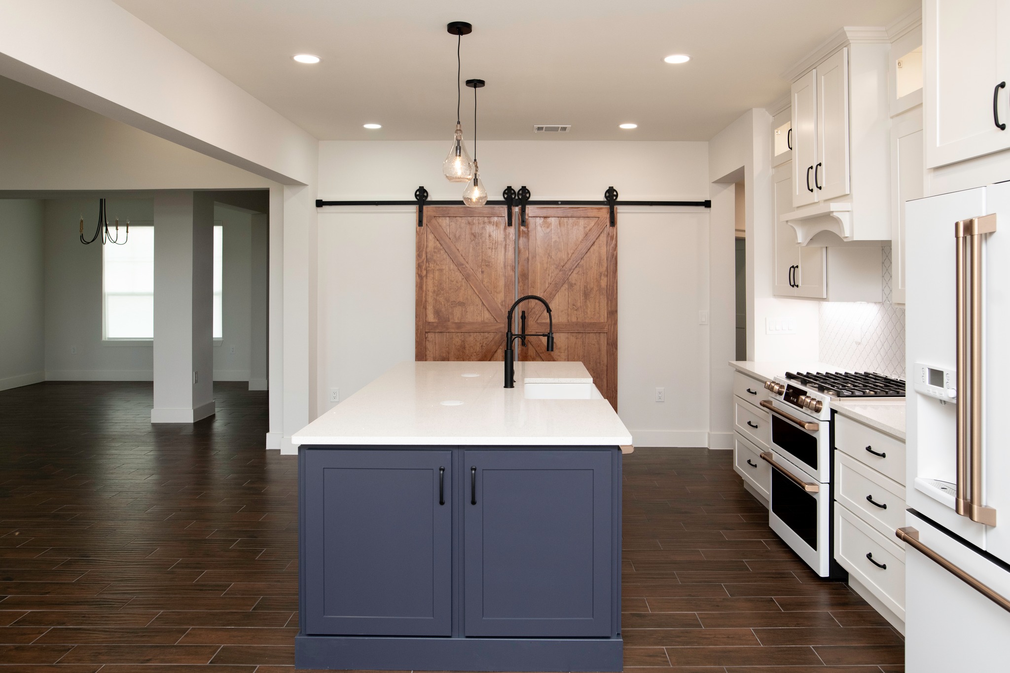White kitchen island with farmhouse sink and sliding barn doors