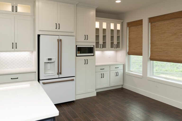 White kitchen with paneled refrigerator and glass-front upper cabinets