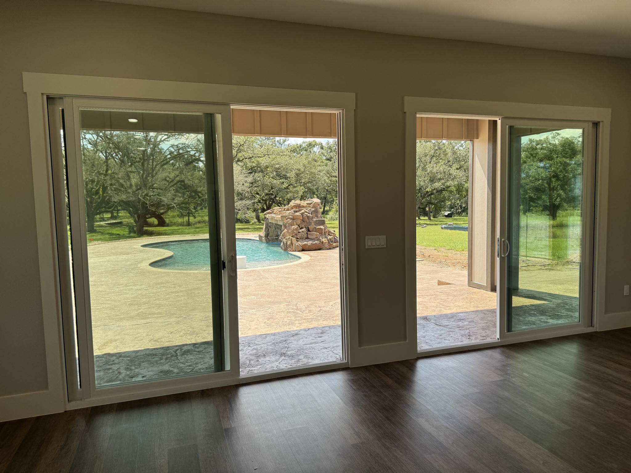 Living room with large glass doors and backyard view in a Hawkeye Construction custom home