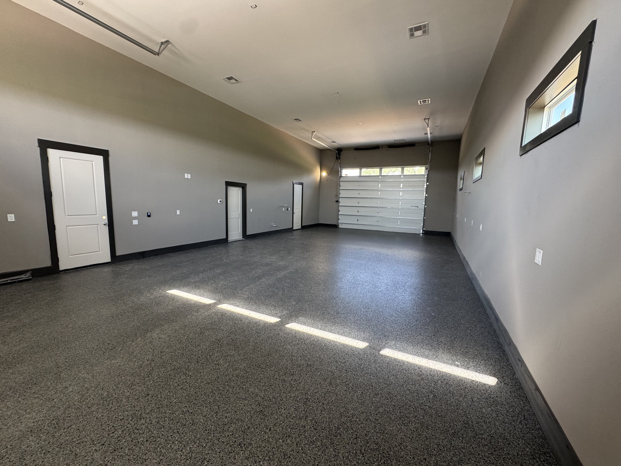 Large finished garage interior with multiple overhead doors