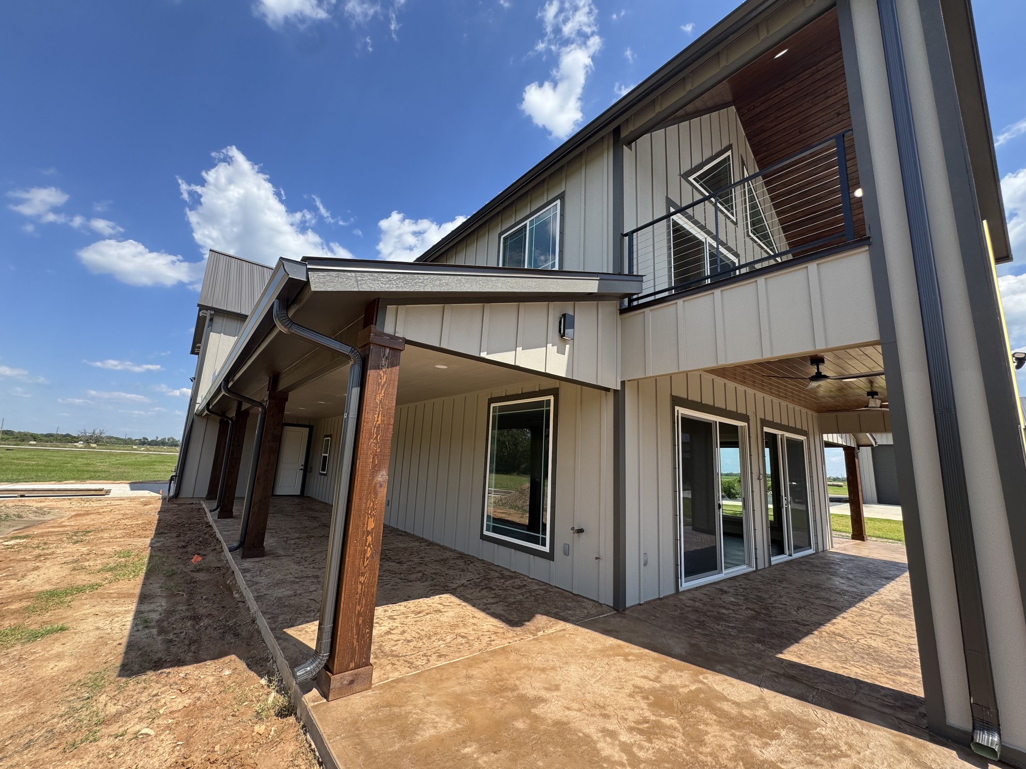 Two-story custom home exterior with covered patio and balcony