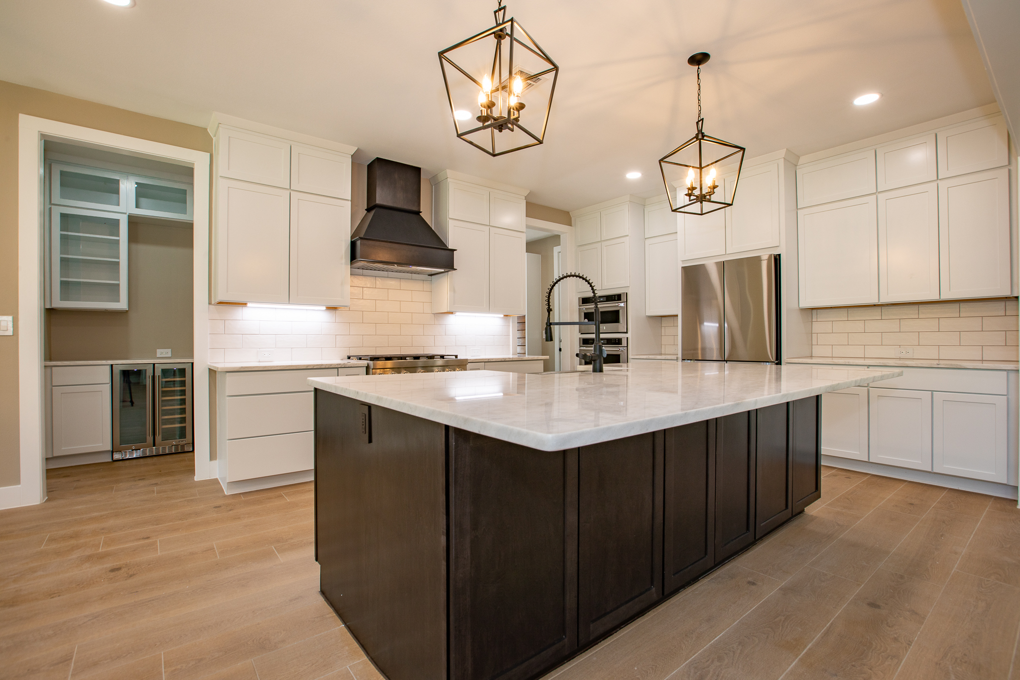 Bright kitchen with large island, pendant lights, and wood cabinetry