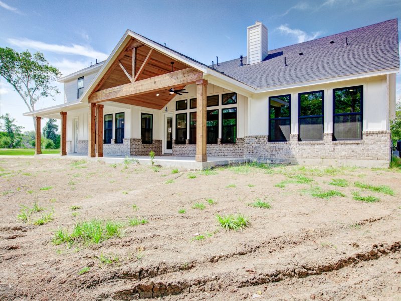 Custom home exterior with timber beams and covered front porch