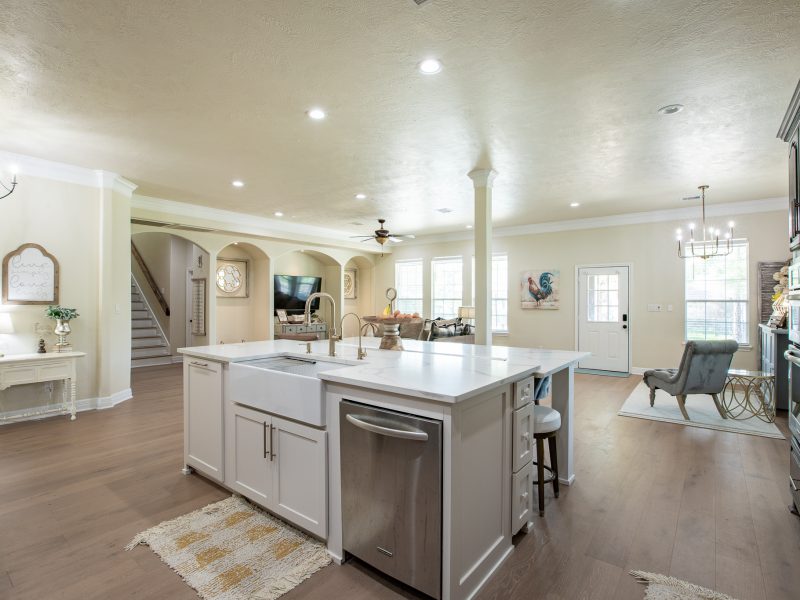 Bright white kitchen with island, stainless appliances, and recessed lights