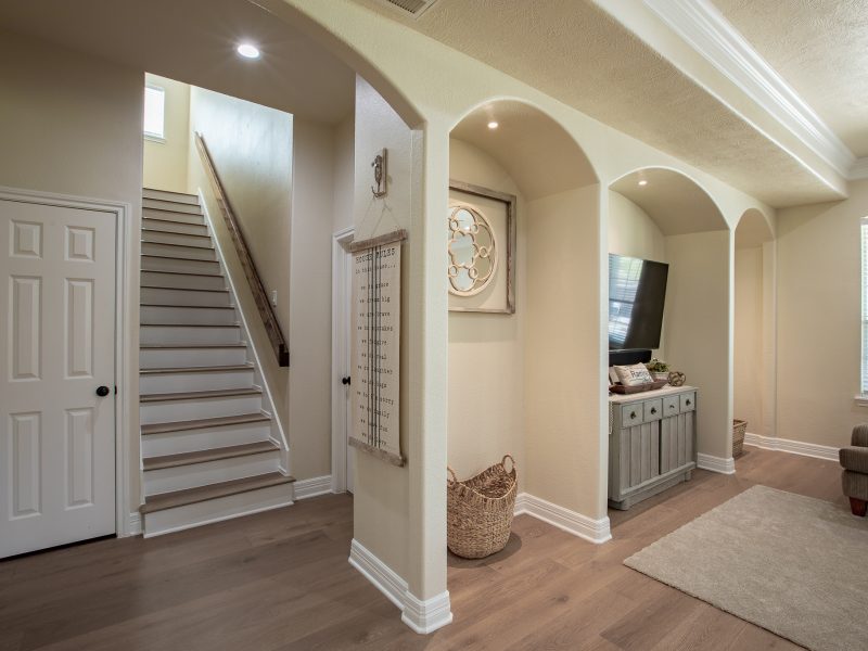 Curved staircase and arched hallway in custom home interior