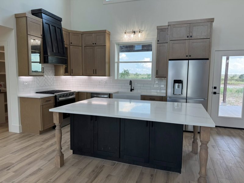 Kitchen with dark island, wood cabinetry, and modern finishes