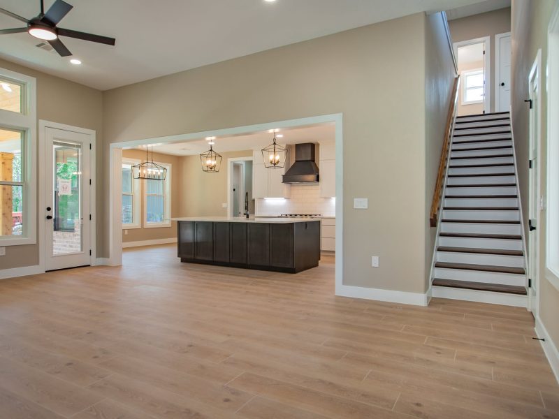 Open living room with staircase and kitchen beyond.