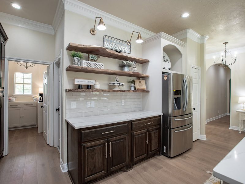Open wood shelving, subway tile and dark wood cabinets.