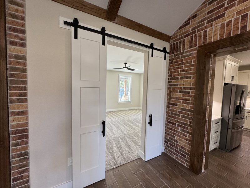 White barn doors framed by exposed brick.