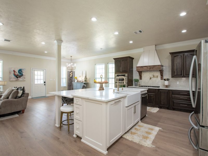 White island with farmhouse sink and dark wood cabinets.