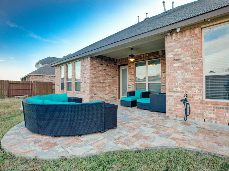 Brick backyard patio with hot tub and covered seating area