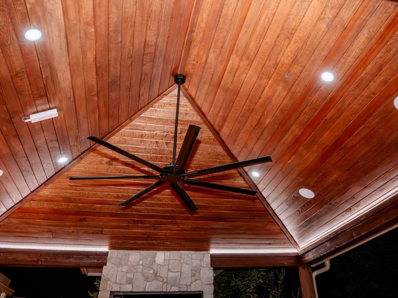 Vaulted wood pavilion ceiling with a large fan and recessed lights